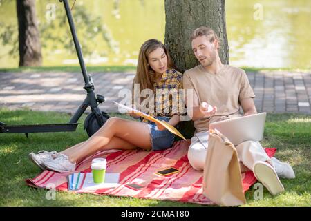 Deux jeunes discutant de quelque chose et regardant s'impliquer Banque D'Images