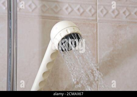 Pomme de douche dans une salle de bains entièrement carrelée, Banque D'Images