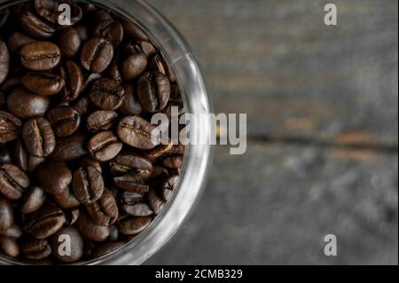 Grains de café arabica frais dans un petit pot sur une table en bois. Grains de café frais. Banque D'Images