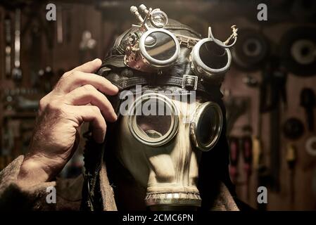 Un homme dans un respirateur et des lunettes dans le style de steampunk, vêtu d'un pardessus, concept postapokalipsis. Banque D'Images