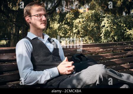 Le commis de bureau est assis sur le banc dans le parc Banque D'Images