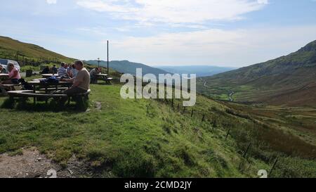 Les gens assis au soleil à Kirkstone Pass Inn Lake District Royaume-Uni Banque D'Images