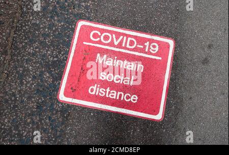 COVID 19 marqueurs sociaux de distance sur la chaussée Banque D'Images