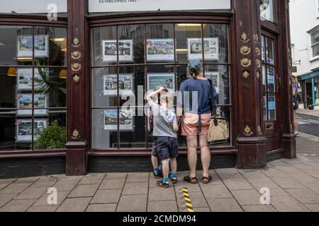 Les familles qui cherchent des agents immobiliers fenêtres dans les propriétés pendant leurs vacances à Dartmouth, South Hams, Devon, Angleterre, Royaume-Uni Banque D'Images