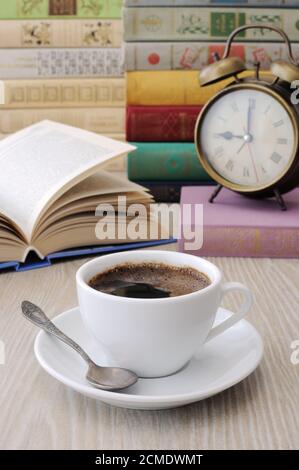 Une tasse de café sur une table parmi des livres Banque D'Images
