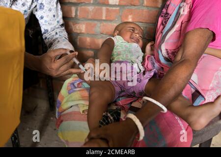 FENI, BANGLADESH - SEPTEMBRE 17 : un assistant sanitaire applique un vaccin à un enfant dans une zone rurale du Bangladesh le 17 septembre 2020. Le Pro étendu Banque D'Images