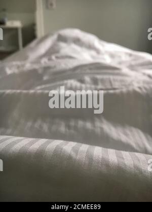 Gros plan sur une couette blanche dans une chambre Banque D'Images