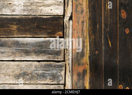 Détail de la vieille porte en bois non peinte avec des lamelles horizontales et verticales et avec beaucoup de texture. Banque D'Images