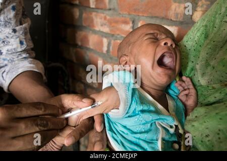 FENI, BANGLADESH - SEPTEMBRE 17 : un assistant sanitaire applique un vaccin à un enfant dans une zone rurale du Bangladesh le 17 septembre 2020. Le Pro étendu Banque D'Images