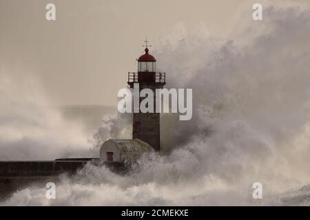 Vieux phare à l'embouchure du Douro pendant la tempête en mer au coucher du soleil. Banque D'Images
