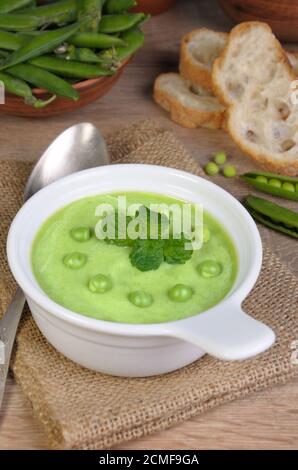 Une assiette de soupe purée de petits pois à la menthe sur une table Banque D'Images