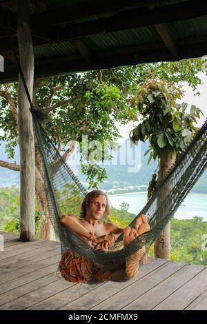 Casual homme heureux de vous détendre sur un hamac dans la plage vacances Banque D'Images