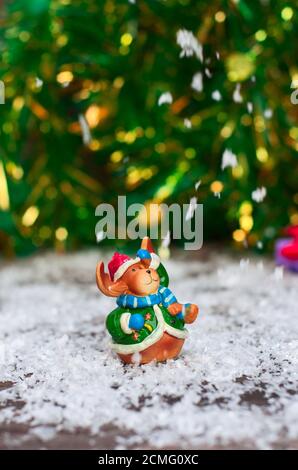 Jouets de Noël en céramique elk en vêtements de fête, debout dans la neige, la neige sur le haut de jette Banque D'Images