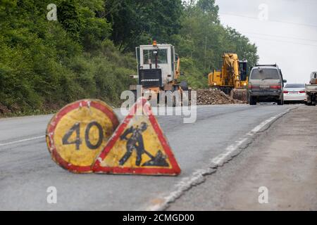 Réparation d'une mauvaise route. Les travailleurs pavent une mauvaise route dans une forêt en Russie. Banque D'Images