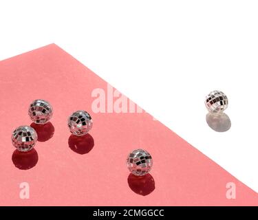 Décorations de Noël minimales, boules disco miroir sur fond géométrique blanc rose. Papier rose avec décorations de Noël isolées sur blanc. Banque D'Images