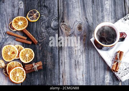 Tasse de café chaud avec des tranches d'orange sur une surface en bois gris Banque D'Images