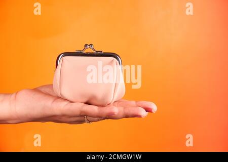 porte-monnaie pour femmes à portée de main sur fond orange Banque D'Images