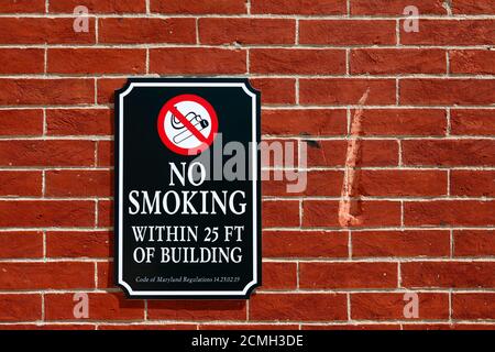 Panneau « interdiction de fumer à moins de 25 mètres du bâtiment » sur le mur de briques devant Oriole Park, Camden yards, Baltimore, États-Unis Banque D'Images