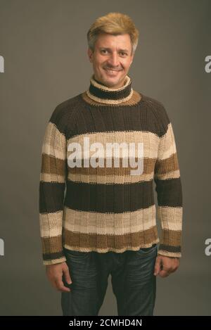 Portrait d'un homme heureux aux cheveux blonds portant un pull à col roulé Banque D'Images