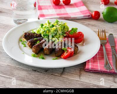 petits pains de viande hachés épicés avec salade sur une assiette Banque D'Images