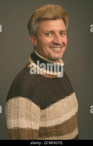 Portrait d'un homme heureux aux cheveux blonds portant un pull à col roulé Banque D'Images