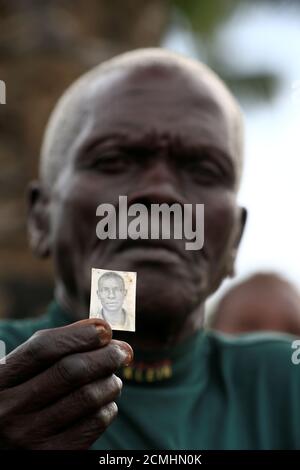 Qui A Tue Simon Qui Ment Simon Wani, réfugié du Sud-Soudan, montre la photo de son fils qui a