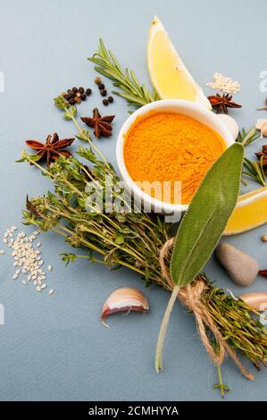 Assaisonnement kari et un bouquet de thym frais sur fond bleu pastel clair. Banque D'Images