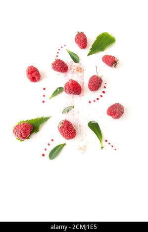 Framboises mûres, feuilles de menthe et gouttes de confiture sur fond blanc. Banque D'Images