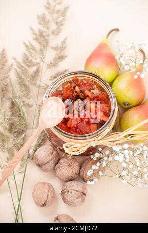 Confiture de poires dans un pot sur fond jaune clair pastel. Banque D'Images