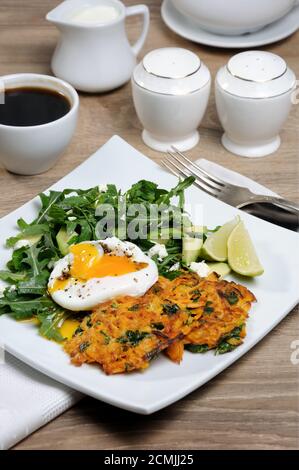 L'idée du brunch. Œufs pochés avec des crêpes d'épinards à la citrouille et garniture d'arugula, d'avocat, de menthe Banque D'Images