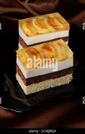 Gâteau empilé de caramel, mousse aux pommes, chocolat et biscuit aux amandes Banque D'Images