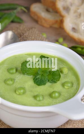 Une assiette de soupe purée de petits pois à la menthe sur une table Banque D'Images