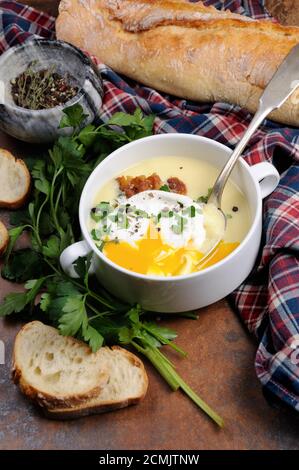 Pomme de terre à l'ail soupe de crème aux lardons et œufs pochés, herbes, épices Banque D'Images