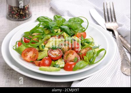 Tranches d'avocat délicates avec tomates, habillé de sauce pesto. Banque D'Images