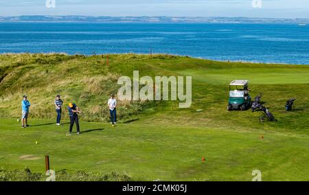 East Lothian, Écosse, Royaume-Uni, 17 septembre 2020. Météo au Royaume-Uni : la vague de chaleur la rend sur la côte est de l'Écosse. Golfeurs sur le terrain de golf de Glen comme un joueur de golf frappe une balle de golf à North Berwick sur le sommet de la falaise avec une vue sur le Firth of Forth Banque D'Images