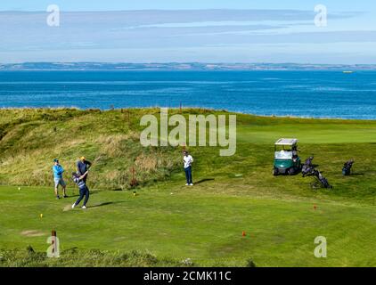 East Lothian, Écosse, Royaume-Uni, 17 septembre 2020. Météo au Royaume-Uni : la vague de chaleur la rend sur la côte est de l'Écosse. Golfeurs sur le terrain de golf de Glen comme un joueur de golf frappe une balle de golf à North Berwick sur le sommet de la falaise avec une vue sur le Firth of Forth Banque D'Images