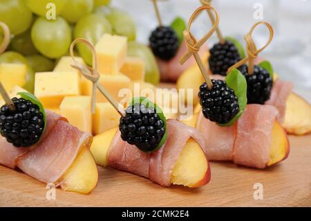 Canape de peach avec jambon séché et les mûres Banque D'Images