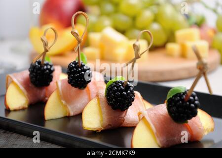 Canape de peach avec jambon séché et les mûres Banque D'Images