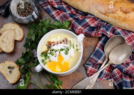 Pomme de terre à l'ail soupe de crème aux lardons et œufs pochés, herbes, épices Banque D'Images