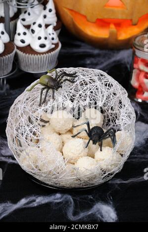 Gaufre bonbons boules dans la forme d'oeufs d'araignées dans un cocon avec une araignée sur la table pour l'Halloween Banque D'Images