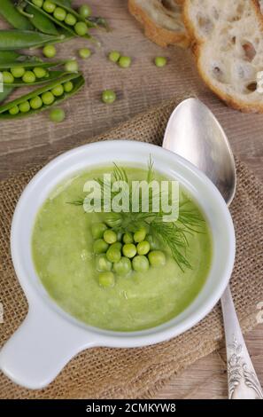 Une assiette de soupe purée de pois verts à l'aneth sur une table Banque D'Images