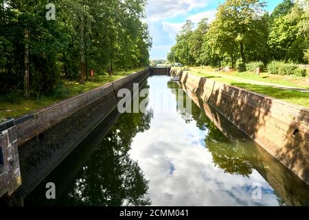 Chambre à moitié remplie dans la rivière aller près de celle, en Allemagne, avec des arbres sur le bord ensoleillé du bassin de l'écluse Banque D'Images