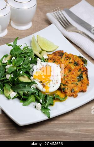 L'idée du brunch. Œufs pochés avec des crêpes d'épinards à la citrouille et garniture d'arugula, d'avocat, de menthe Banque D'Images