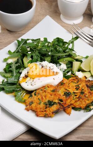 L'idée du brunch. Œufs pochés avec des crêpes d'épinards à la citrouille et garniture d'arugula, d'avocat, de menthe Banque D'Images