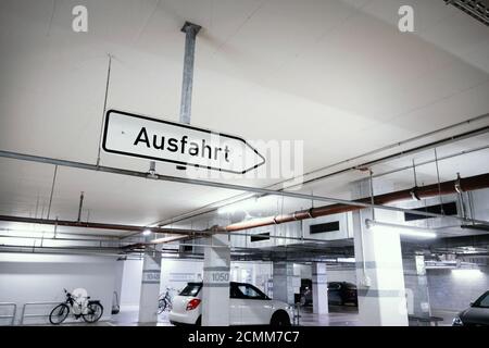 Depuis le plafond d'un parking souterrain, un panneau indiquant « Ausfahrt » - sortie est suspendu. Banque D'Images