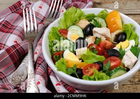 Salade de légumes avec du poulet et des œufs, des olives dans la région de feuilles de laitue. Plan horizontal. Banque D'Images