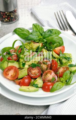 Tranches d'avocat délicates avec tomates, habillé de sauce pesto. Banque D'Images