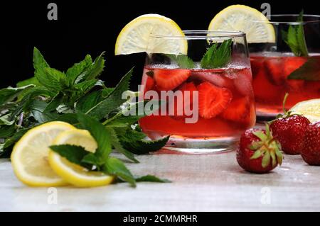 Un verre de limonade aux fraises réfrigérés, les feuilles de menthe, une rondelle de citron avec de la glace Banque D'Images