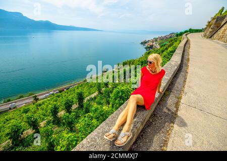 Sentier de randonnée entre les terrasses de vignobles surplombant le lac Léman. Femme touriste blonde appréciant sur la visite dégustation de vin dans les terrasses du vignoble de Lavaux Banque D'Images