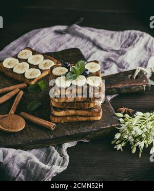 Toasts à la française carré de pain blanc avec du chocolat et des morceaux de banane Banque D'Images